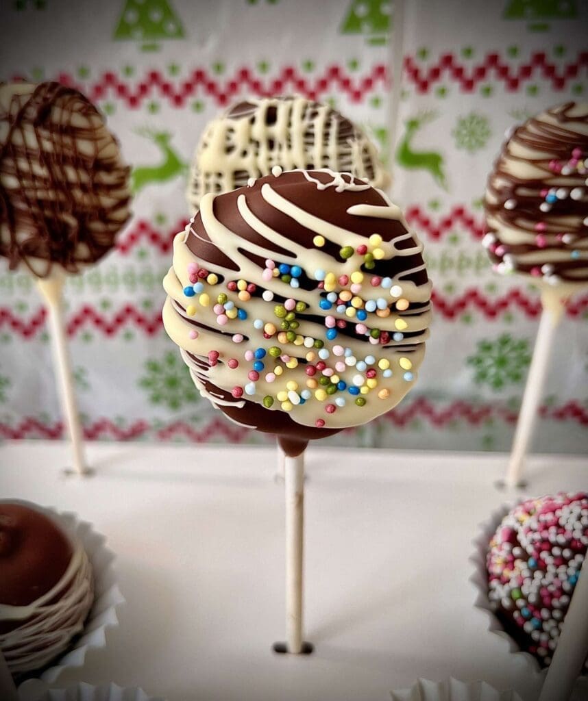 Un petit gâteau arrondi de la taille d’une grosse bille qui est recouvert d’un glaçage, de chocolat ou de décorations, puis est fixé sur un bâton de sucettes.