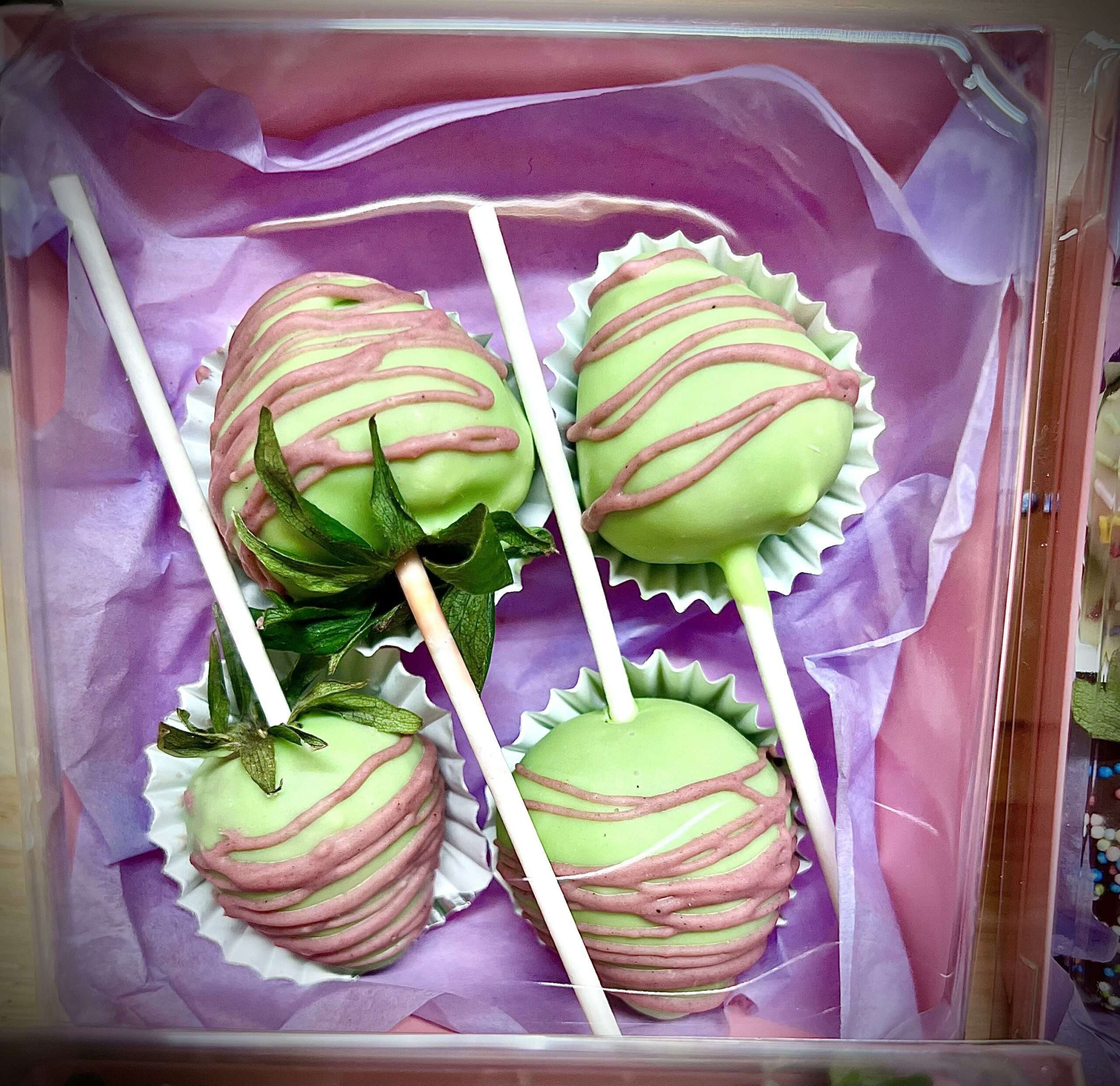 Les 4 sucettes Fraises enrobées de chocolat blanc teintées en vert.